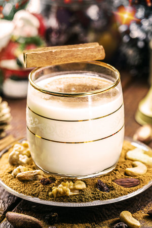 winter drink made with eggs, liqueur and cinnamon, called eggnog, decorated with nuts and dried fruitの写真素材