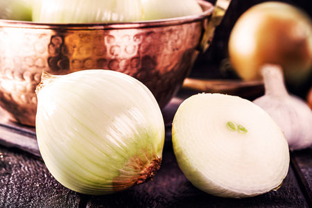 large Brazilian onions in rustic copper pot, shelled vegetables, seasoning or culinary ingredientの写真素材