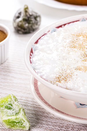 rice pudding bowl, homemade pudding made from ground rice, sweetened with cinnamon powder and cinnamon bark. Rural Brazilian sweets in the background, typical June festival foodの写真素材