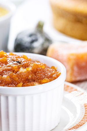 pot with homemade pumpkin jam, typical Brazilian dessert at the June and July parties, in the background cornmeal cake and sweetsの写真素材