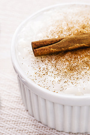 bowl with sweet rice pudding, with cinnamon stick and cinnamon powder, homemade dessert, typical sweet from Brazil at the June festivalsの写真素材