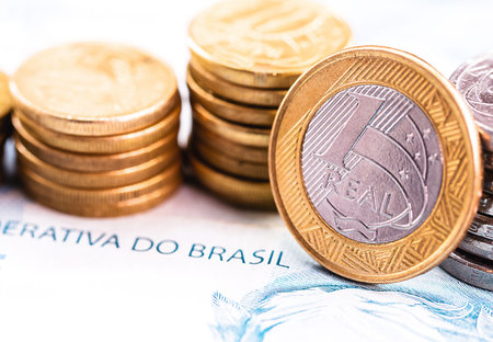 one real coin and gold bars. Concept of appreciation of the Brazilian currency in the stock market.