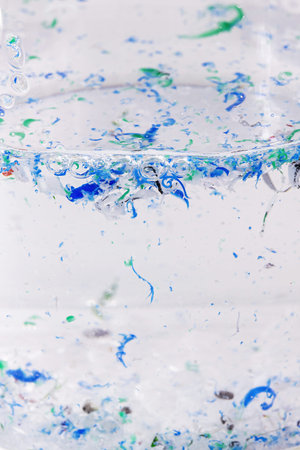 Cup with polluted water, contaminated with traces of plastic and micro plastic, polymer particles...