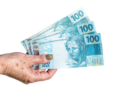 female hand holding 100 reais bank notes, concept of retirement or government aidの写真素材