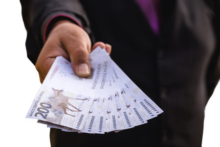 hand holding money bills, value 200 reais