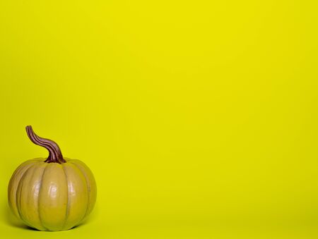 Green decorative thanksgiving pumpkin front view on a green yellow background with room for textの写真素材