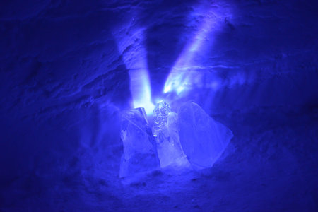 A small light source causes exploding purple rays to spread out from behind these chunks of ice....
