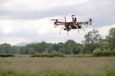Large hex copter camera drone hovers in front of a rural back ground of the malvern hills....