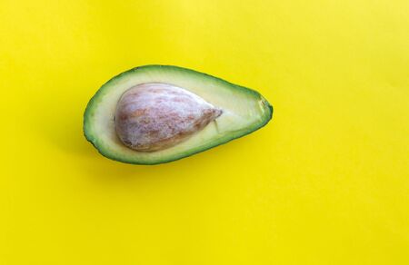 Half part of avocado on yellow backgroundの写真素材