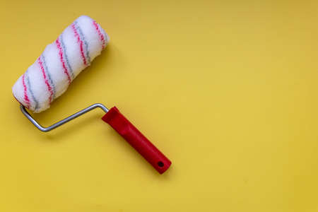 Paint roller for painting and priming new on yellow Backgroundの写真素材