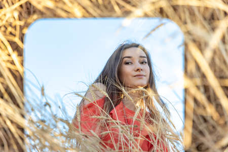 Brunette Red dress girl looking herself reflectionの写真素材