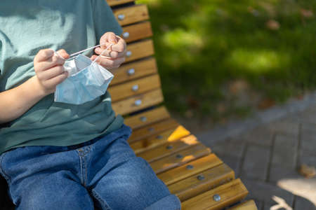 Medicine mask in kids hands close up. Outdoor.の写真素材