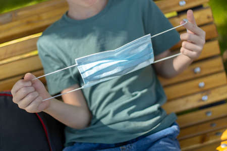 Medicine mask in kids hands close up. Outdoor.の写真素材