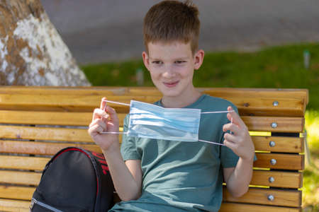 Young caucasian boy looking at the medicine mask then wearing itの写真素材
