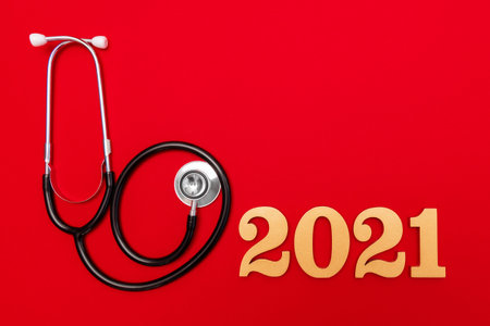 Stethoscope 2021 gold number on red background. Happy New Year