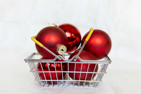 Red Xmas balls in shopping cart. New year bubble. marry Christmas conceptの写真素材
