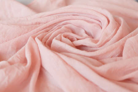 light pink cloth baby girl. Soft muslin baby blanket background. Cotton clothing and textiles. Natural organic fabrics texture. Close up.の写真素材