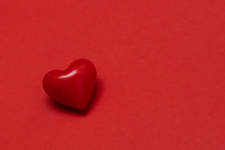 Valentines day red heart on same color background. Monochromatic vivid color. Valentine's day concept. Close up, copy spaceの写真素材
