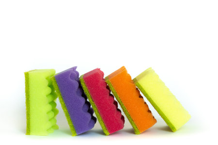 Stack of many multi-colored dish wash sponges isolated on white background. Household cleaning scrub pad.の写真素材