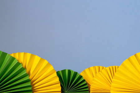 Spring, easter, summer banner. Decor pattern paper fan on blue background. Yellow green fans.の写真素材