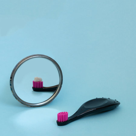 Kids toothbrush with toothpaste mirorr reflection. International day of dentist. Creative concept of daily morning routine.の写真素材