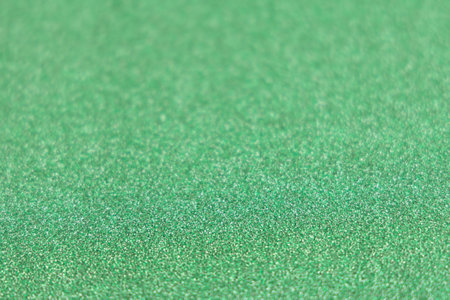 Green shiny glitter paper texture. Shining luxurious fabric. Glimmering golden christmas background paper texture. Shining luxurious fabric. Glimmering light green color st Patric, christmas background.の写真素材