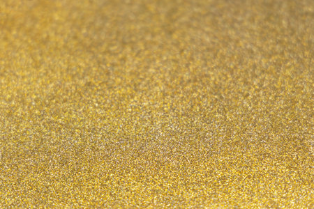 Golden shiny glitter paper texture. Shining luxurious fabric. Glimmering golden christmas backgroundの写真素材