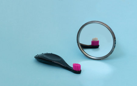 Kids toothbrush with toothpaste mirorr reflection. International day of dentist. Creative concept of daily morning routine. Copy spaceの写真素材