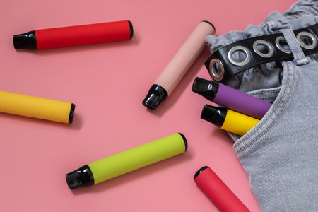 Layout of colorful disposable vapor stick on a light background. Concept of modern e-smoking, vaping and nicotine, electronic cigarettesの写真素材