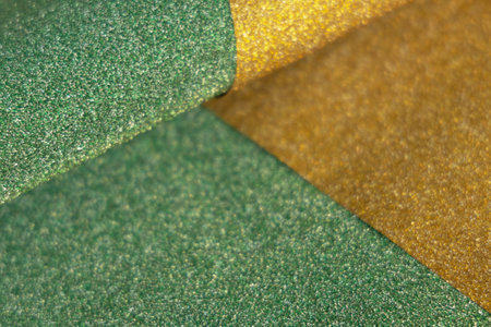 Golden and green wave shiny glitter paper texture. Shining luxurious fabric. Glimmering light green golden color, christmas backgroundの写真素材