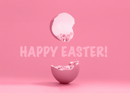 Broken decorative easter egg with colorful confetti. Minimal composition, monochromatic color pastel pink background. Sign happy easterの写真素材