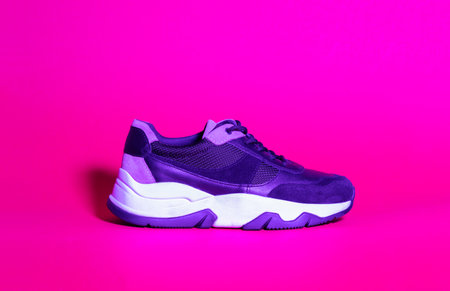 Trendy woman sneakers shoes, trend duotone neon ultraviolet color lightning. Colored light, creative trendy effectの写真素材