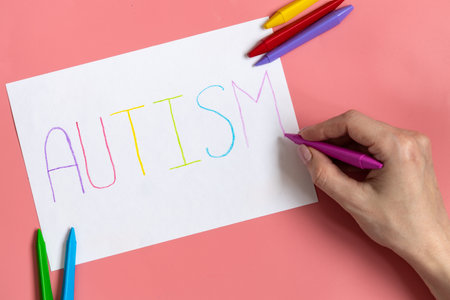 Text word autism on paper sheet written by colorful letter, on blue backgroundの写真素材