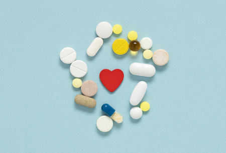 Different pills cardioglogy near red heart. Concept of heart diseases, problems with heart.の写真素材