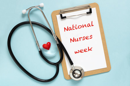 Text International nurses week. Congratulations for nurse day. Flat lay stethoscope, red heart on pastel blue background.の写真素材