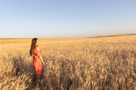Young woman in the wheat field, mental and physical wellbeing concept. Copy space.の写真素材