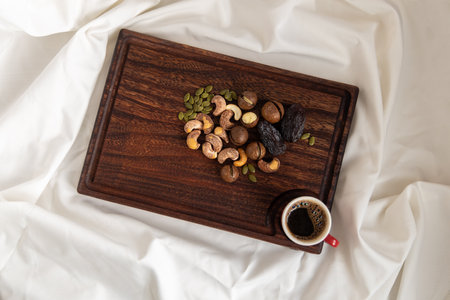 A tasty charcuterie board full of various nuts and coffee for breakfast.の写真素材