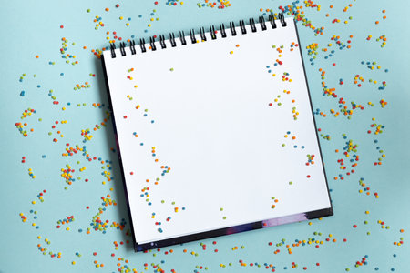Mock up of empty sketchbook on bright vibrant background with colorful confetti. Copy space.の写真素材