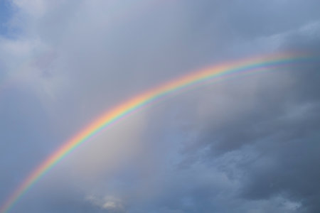 Dark clouds and rainbow in sunset sky. Amazing sky landscape. The sky gives happiness, calmness and peace.の写真素材