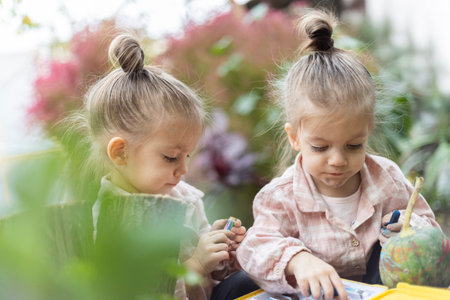 Two girls enthusiastically drawing with colorful pencils, spending time together.の写真素材