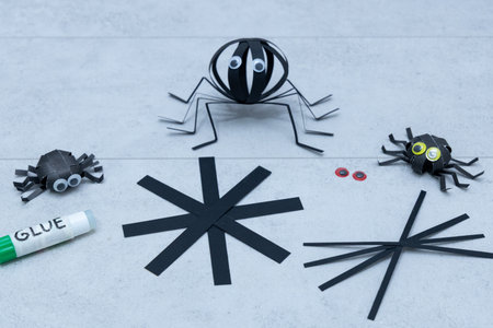 Step 3 of 5 making paper spider for Halloween. Folding and shaping paper strips to create spider for DIY Halloween craftの写真素材