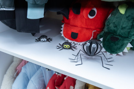 Funny halloween prank with paper spider placed in kids wardrobe, handmade paper craft decoration for spooky holiday atmosphereの写真素材