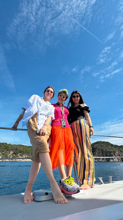 Lloret de Mar, Girona,Spain, May, 25, 2024. Two joyful women in vibrant clothes dancing on a yacht during summer. Celebration of freedom, fun, and lifestyle on the water.のeditorial素材