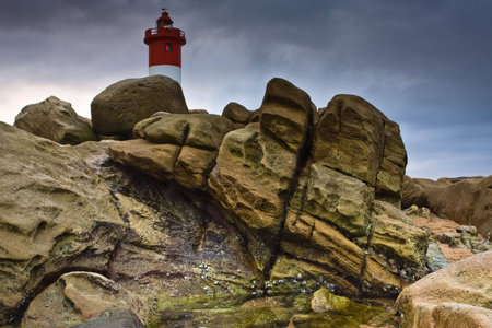 Umhlanga Lighthouse on the rocky coast of South Africaの写真素材
