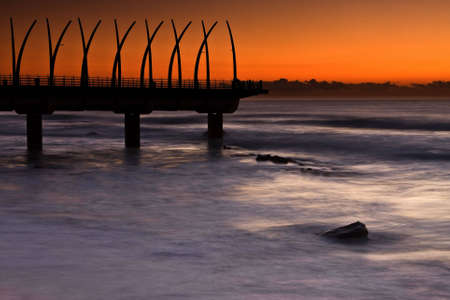 Umhlanga Pier at sunrise with oragne glowの写真素材