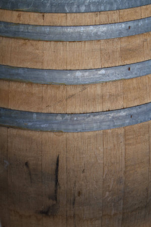 Old wooden wine barrel with metal brace in winery