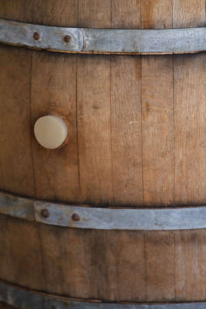 Old wooden wine barrel with metal brace in wineryの写真素材