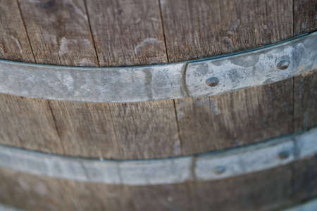 Old wooden wine barrel with metal brace in wineryの写真素材