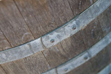 Old wooden wine barrel with metal brace in wineryの写真素材
