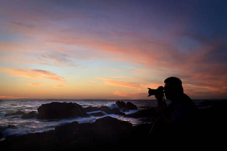 Photographer hard at work taking a seascapeの写真素材